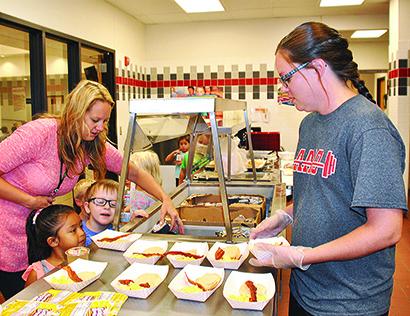 Hermleigh teacher Daysha Cheyne, (left) and cafeteria employee Ashley Benitez helped pre-kindergarten students Ava Carillo and Merrick Shipley make their breakfast choices.