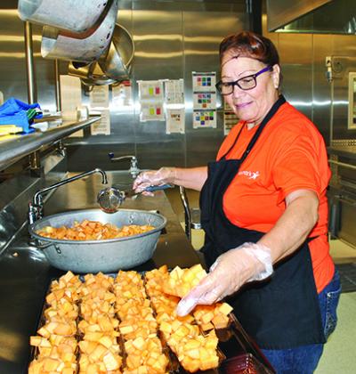 Ofelia Martinez, a Snyder High School cafeteria employee, cut melon at Snyder Junior High School to serve with lunch.